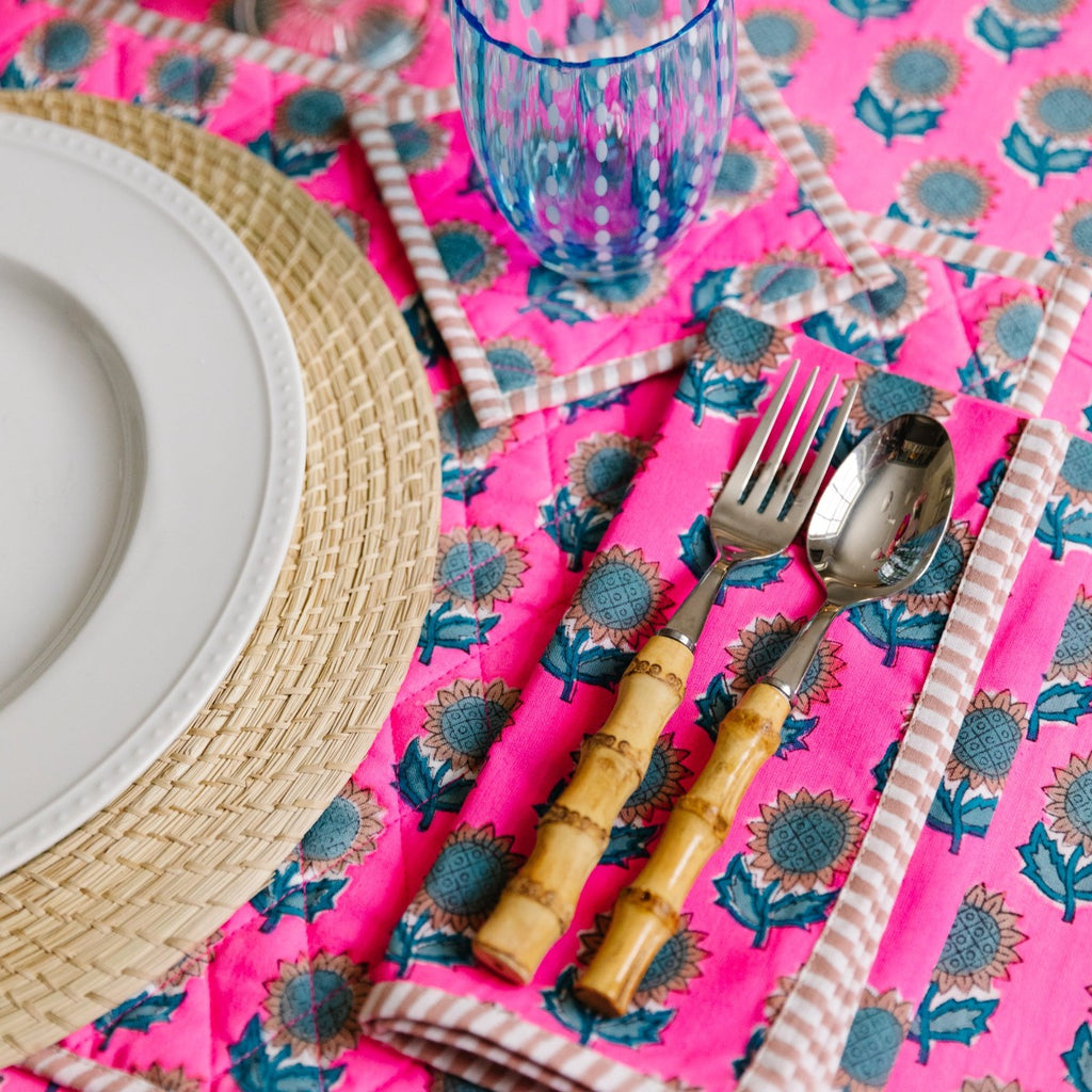 a table setting showcasing Amelia table linens with spoon and fork positioned to the right of the plate, a glass above the silverware and a table cloth beneath all of them