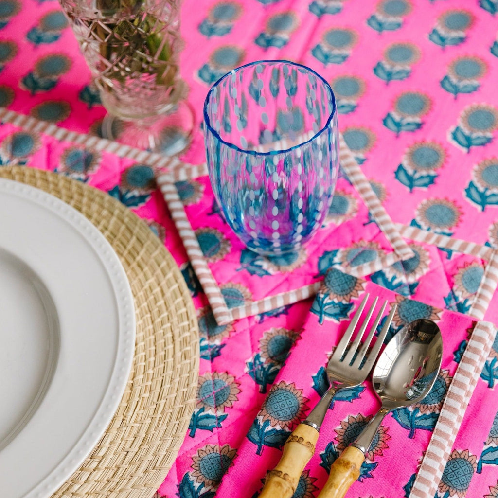 a beautiful table setting showcasing Amelia table linens with spoon and fork positioned to the right of the plate, a glass above the silverware and a table cloth beneath all of them