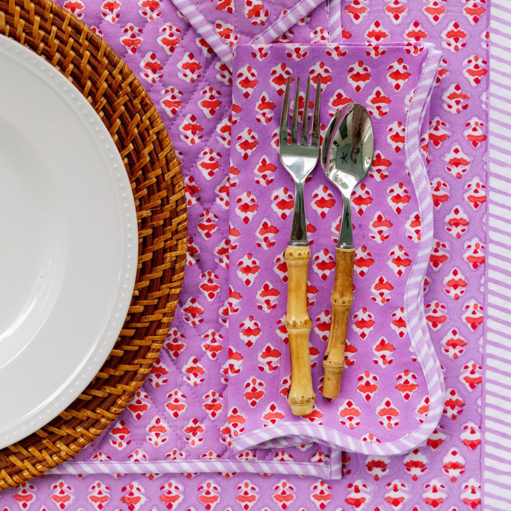 a beautiful table setting showcasing Ambroeus table linens with spoon and fork positioned to the right of the plate, a glass above the silverware and a table cloth beneath all of them