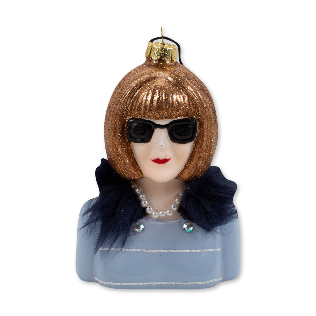 Editor of Vogue, Anna Wintour Christmas tree ornament.  Anna Wintour is wearing a blue tweed jacket with black fur collar and her signature big black sunglasses.