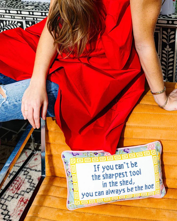 Needlepoint pillows with embroidered phrases and velvet backing